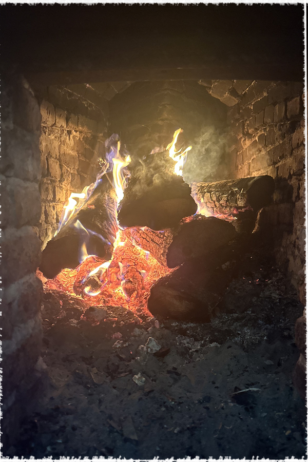 Feu de bois à l'intérieur d'un foyer d'un four traditionnel en briques.